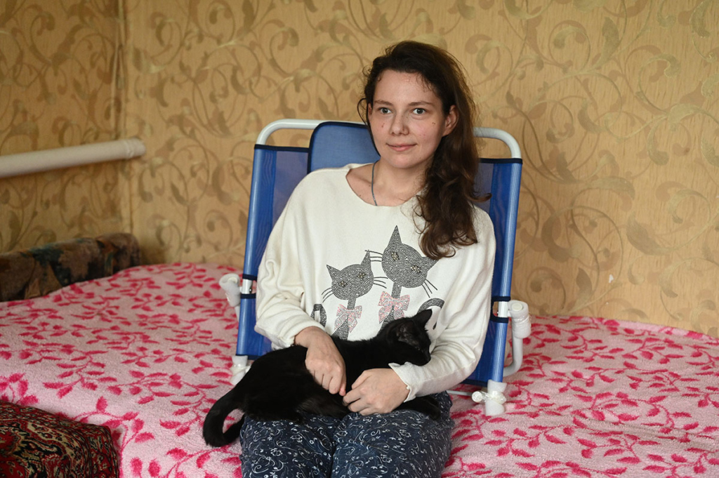 Девушка в специальном поддерживающем кресле с котом