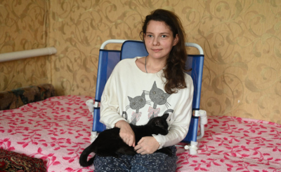Девушка в специальном поддерживающем кресле с котом