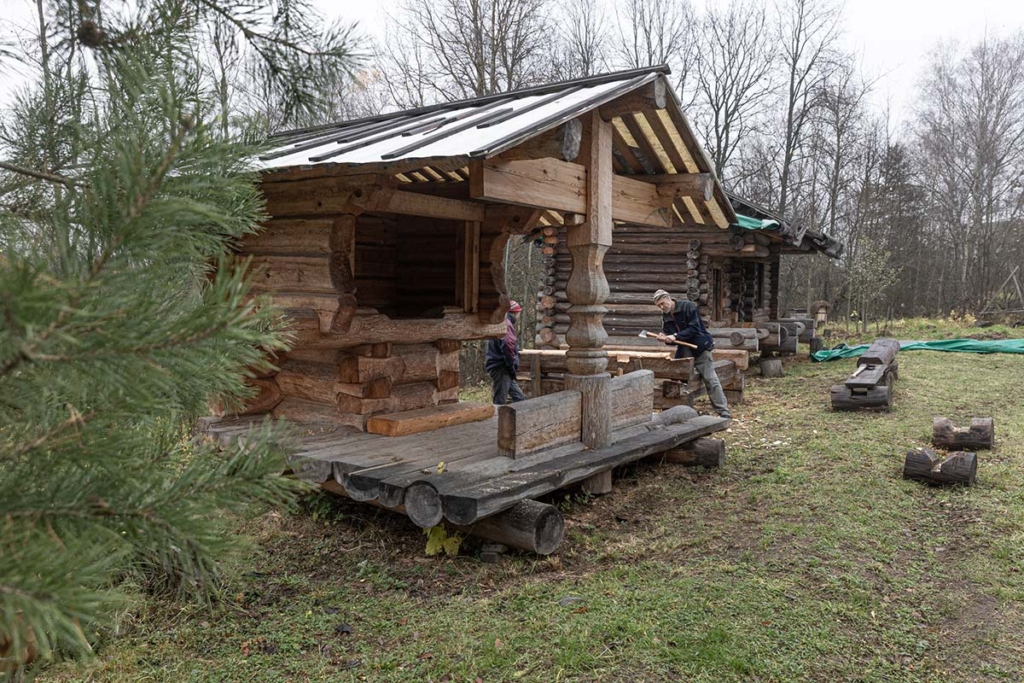 На переднем плане колодец, на заднем плане - работают волонтеры