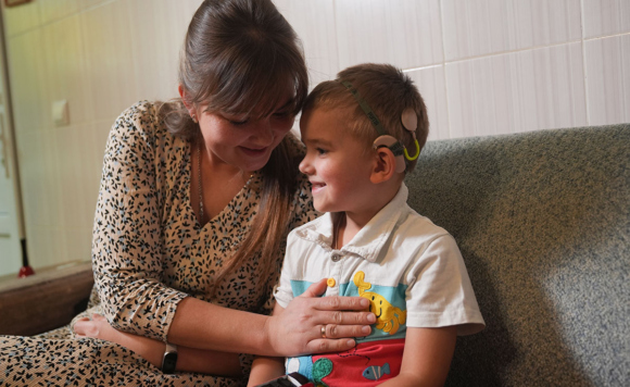 Мальчик в кохлеарном аппарате с мамой