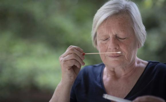 Женщина нюхает лабораторную палочку