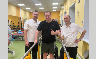 Мужчина с травмой позвоночника в реабилитационном центре с реабилитологами