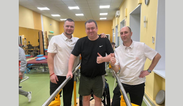 Мужчина с травмой позвоночника в реабилитационном центре с реабилитологами