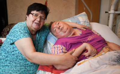 Пожилая женщина с больной лежачей дочкой