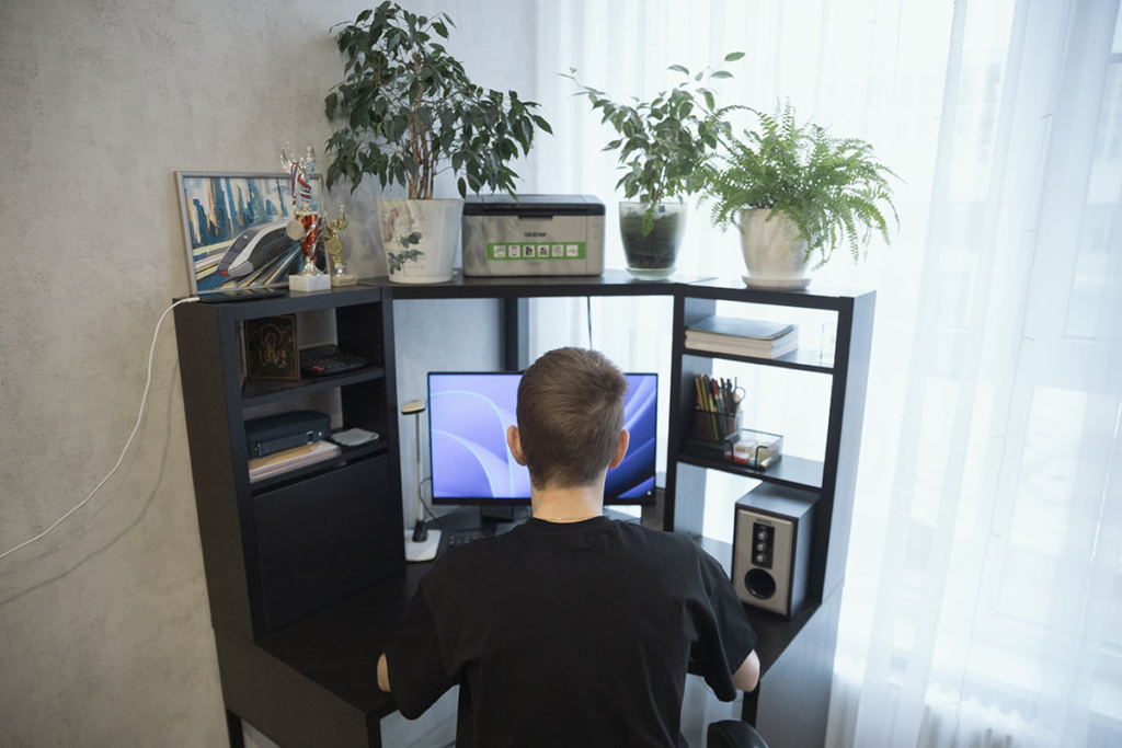 Юноша за компьютером дома