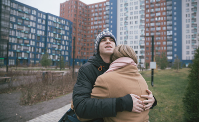 Мама с сыном на фоне многоквартирных домов