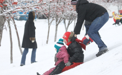 Папа с детьми катается с ледяной горки