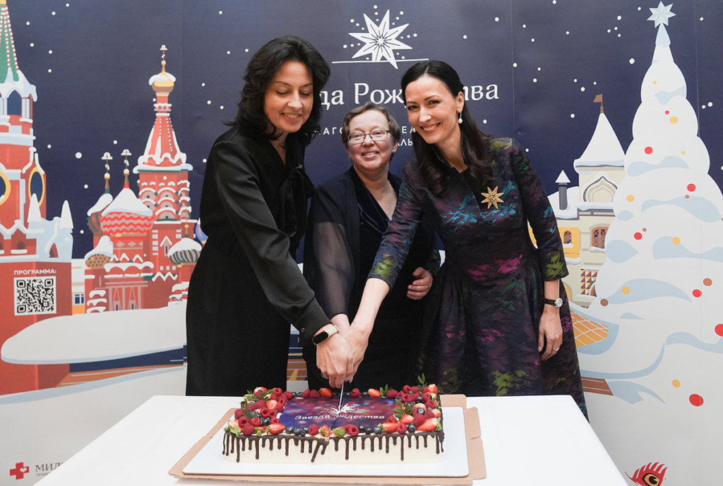 Три молодых женщины разрезают торт