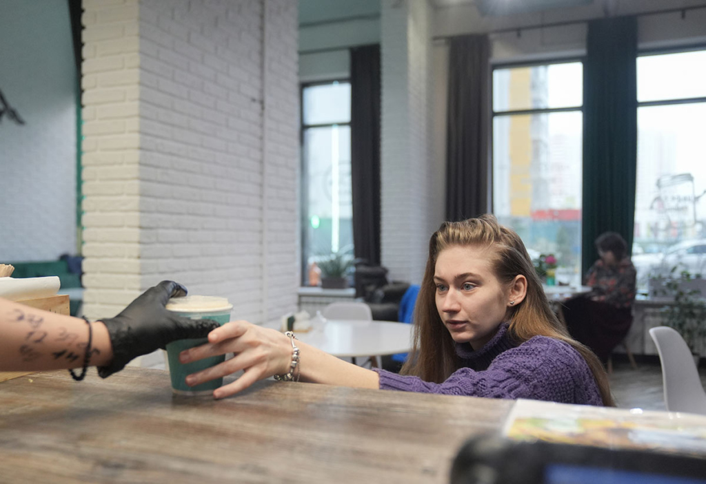 Девушка в инвалидной коляске покупает кофе