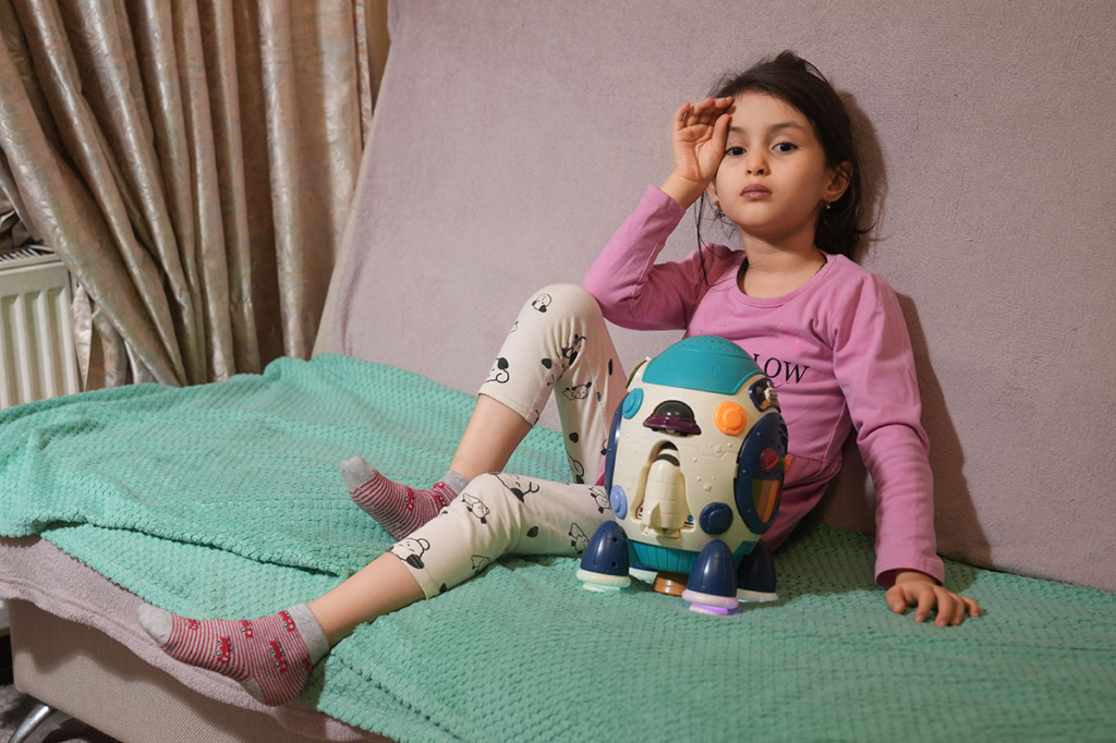 Девочка с игрушкой на диване 