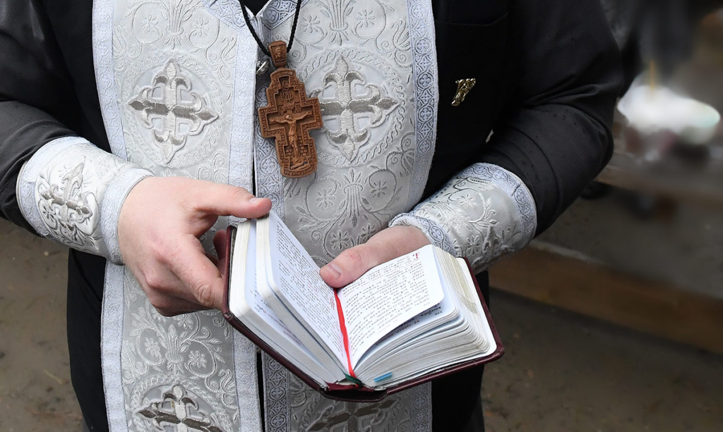Священник читает Евангелие