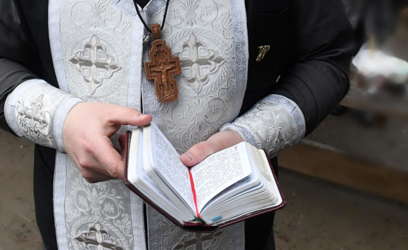 Священник читает Евангелие