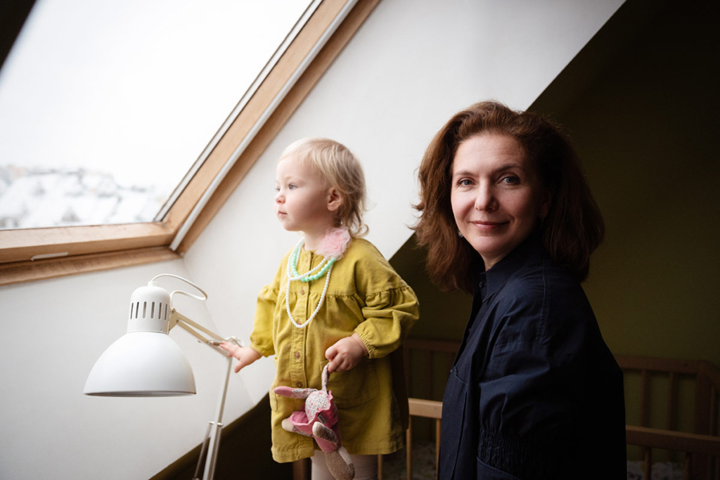 Портрет молодой женщины с маленькой дочкой на фоне окна 