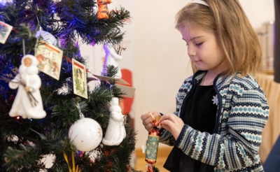 Девочка вешает игрушки на елку
