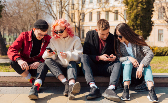 молодые люди сидят в телефонах на улицу