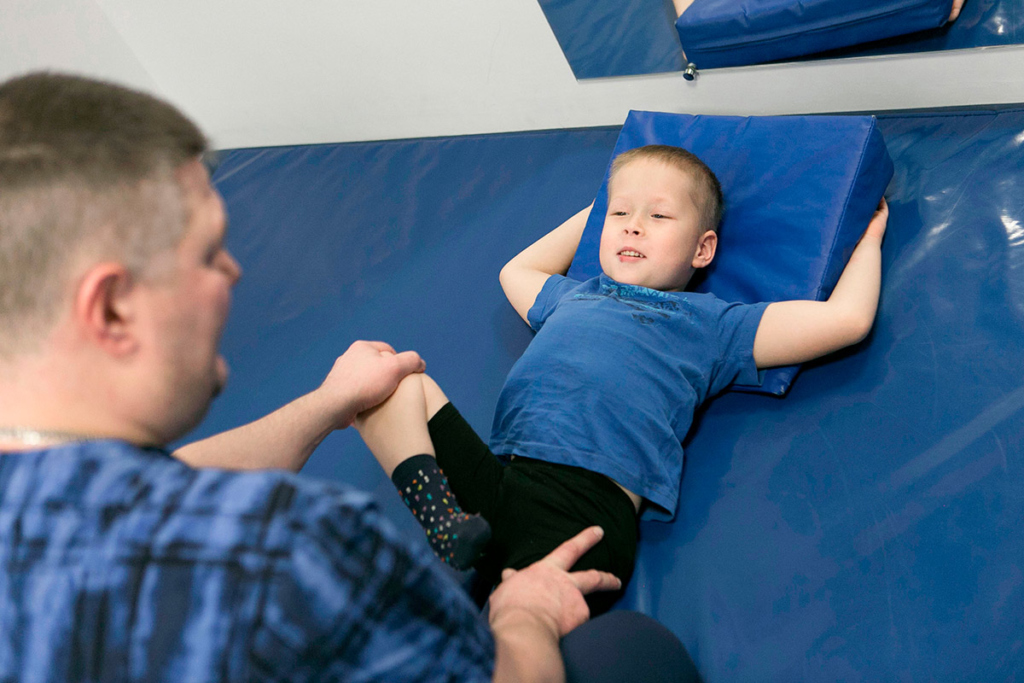 Мальчик на занятиях с реабилитологом 