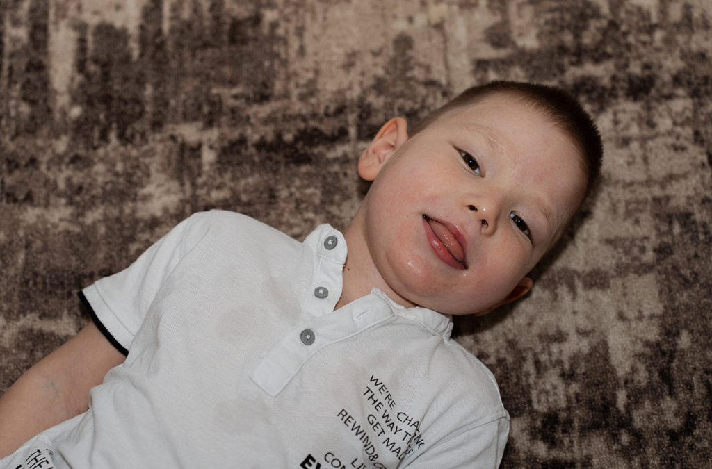 Мальчик лежит на полу на ковре