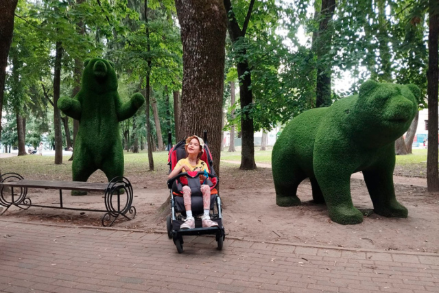 Девочка в специальной инвалидной коляске 