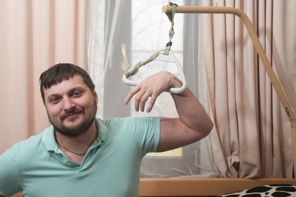 Мужчина у домашнего подъемника с кровати