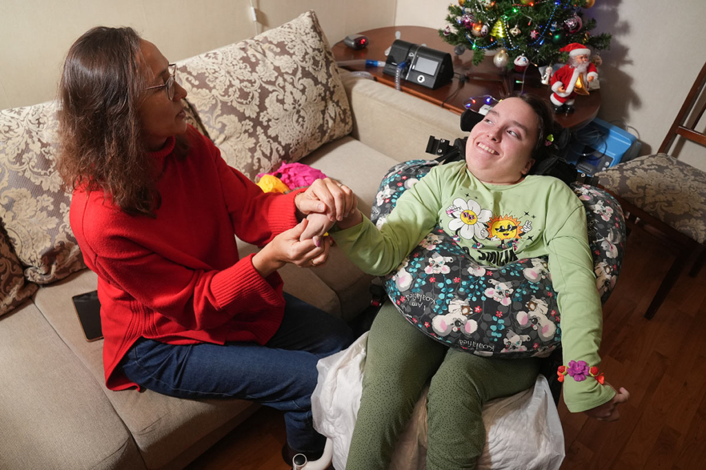 Музыкальный терапевт и больная девушка в инвалидной коляске 