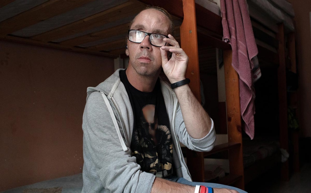 Мужчина сидит на кровати