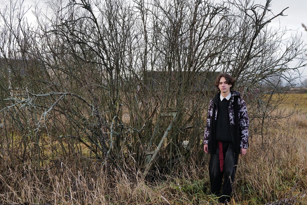 Юноша у зарослей кустарника 