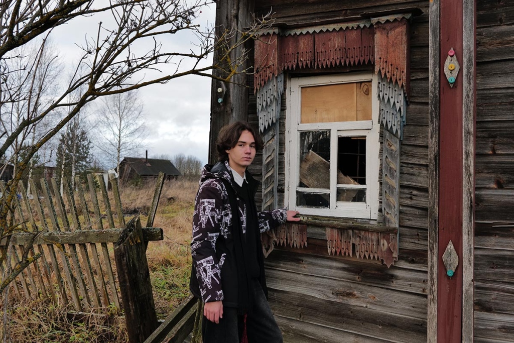 Юноша у окна деревенского дома 