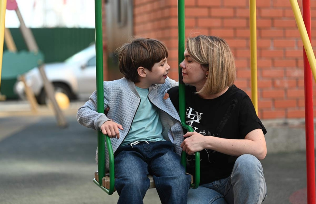 Мальчик с мамой на качелях