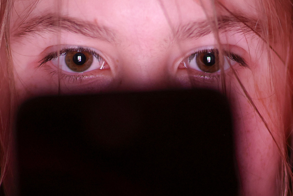 Девушка смотрит в экран телефона