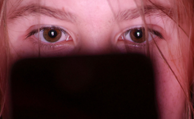 Девушка смотрит в экран телефона