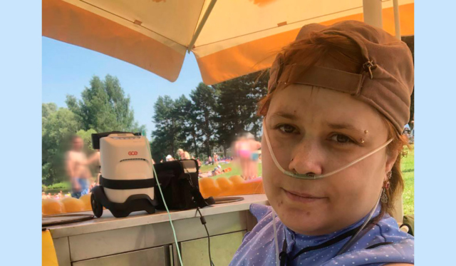 Портрет молодой женщины с портативным кислородным концентратором