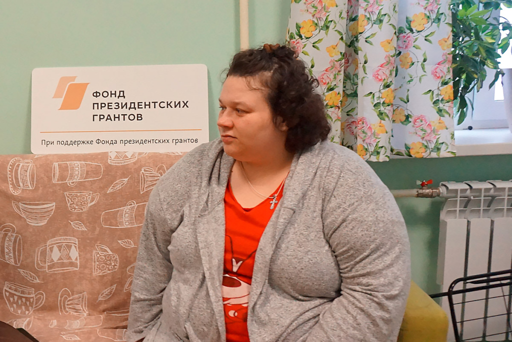 Молодая женщина сидит на диване