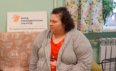 Молодая женщина сидит на диване