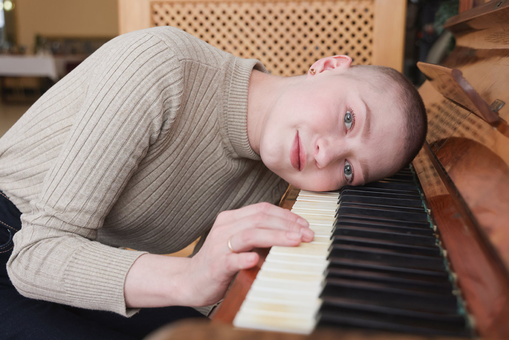 Девушка положила голову на клавиши пианино 