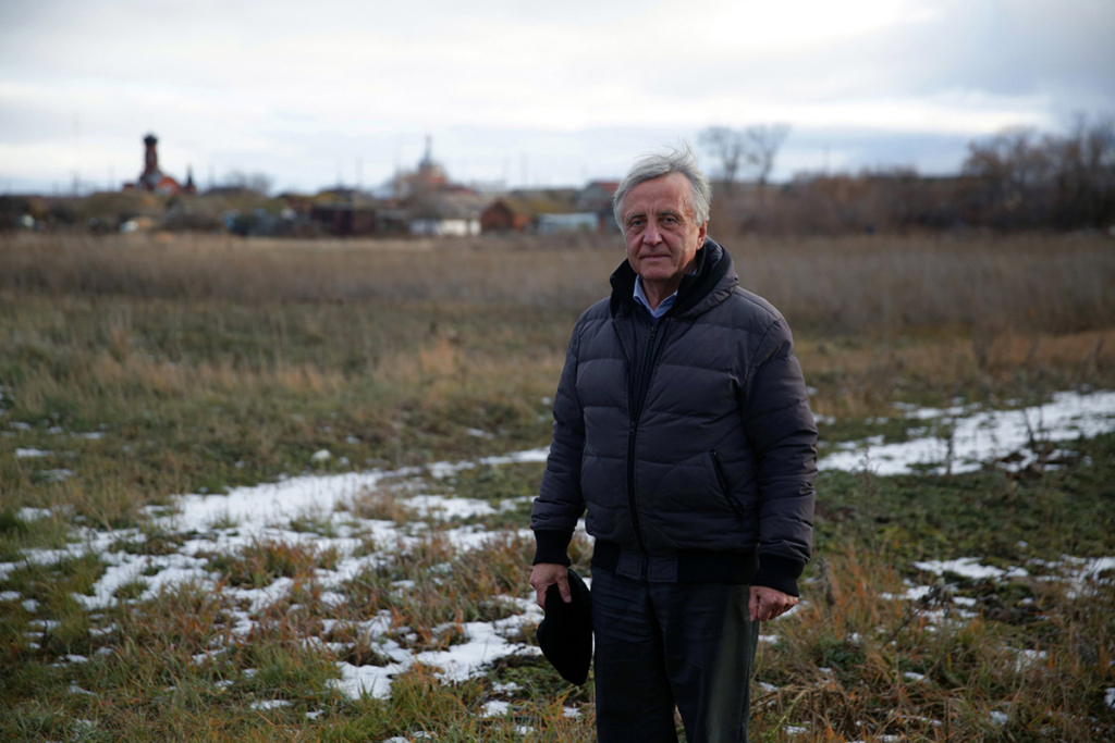 Портрет мужчины на фоне деревни