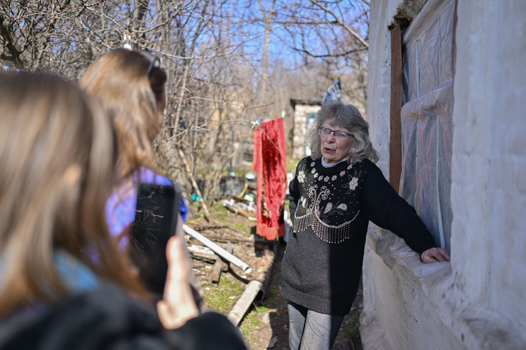 Женщина на фоне своего разрушенного дома