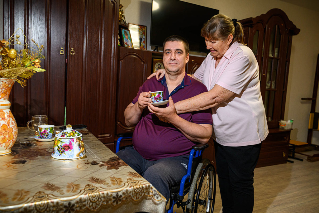 Мужчина на инвалидной коляске, рядом его мама