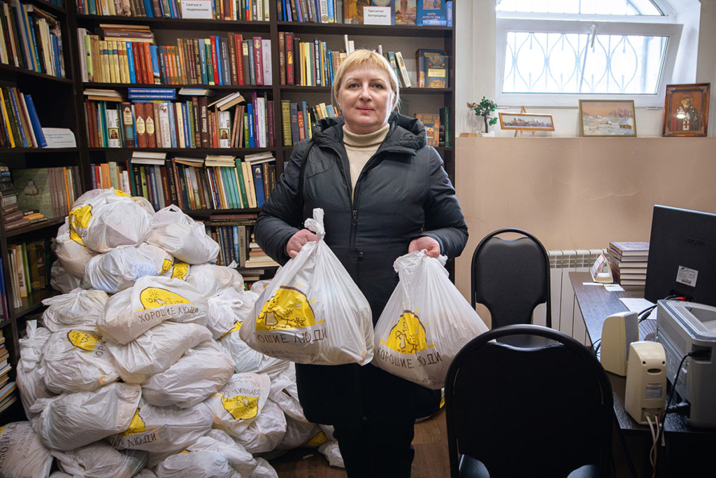 Женщина держит продуктовые наборы