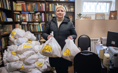 Женщина держит продуктовые наборы