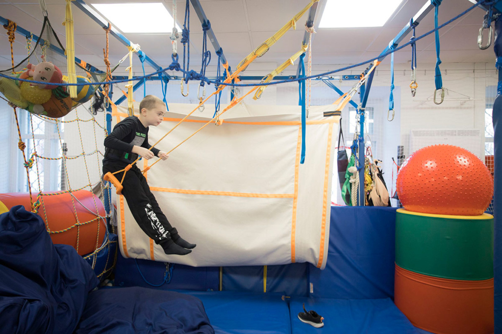 Мальчик на качелях в центре реабилитации 