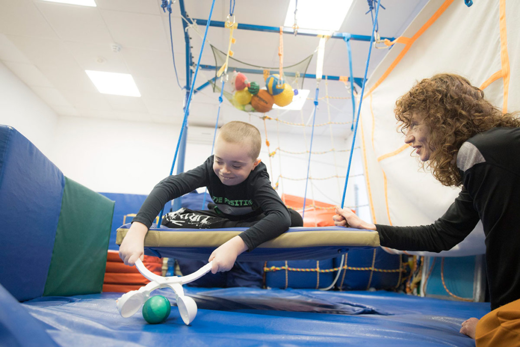 Мальчик на качающейся платформе собирает шарики снеголепом 