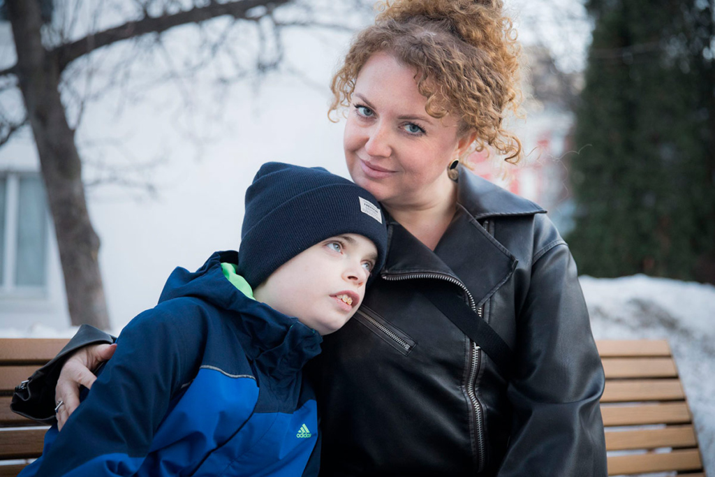 Мама с сыном сидят на скамейке 
