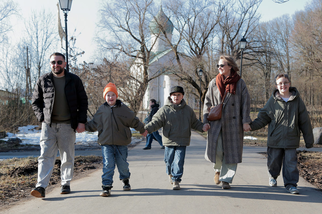 Семья: мама, папа, трое сыновей идут по улице