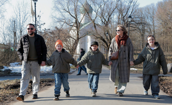 Семья: мама, папа, трое сыновей идут по улице