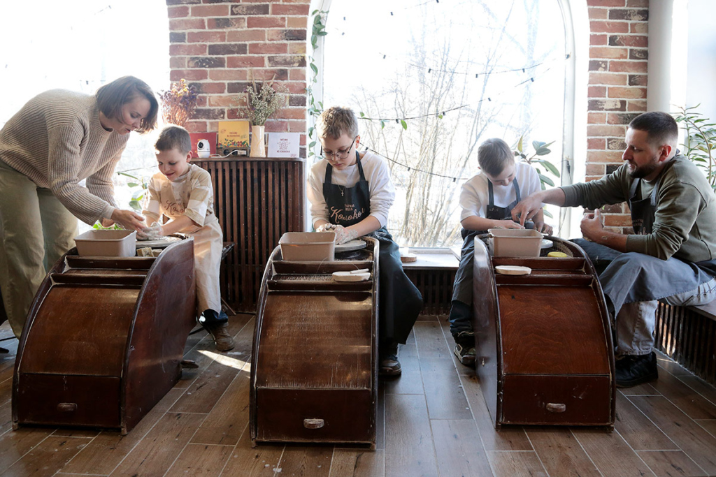 Мама и папа с тремя сыновьями в керамической мастерской 