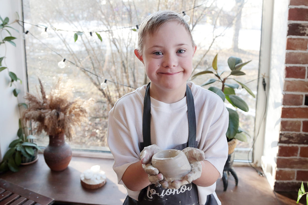 Мальчик в керамической мастерской слепил чашку 