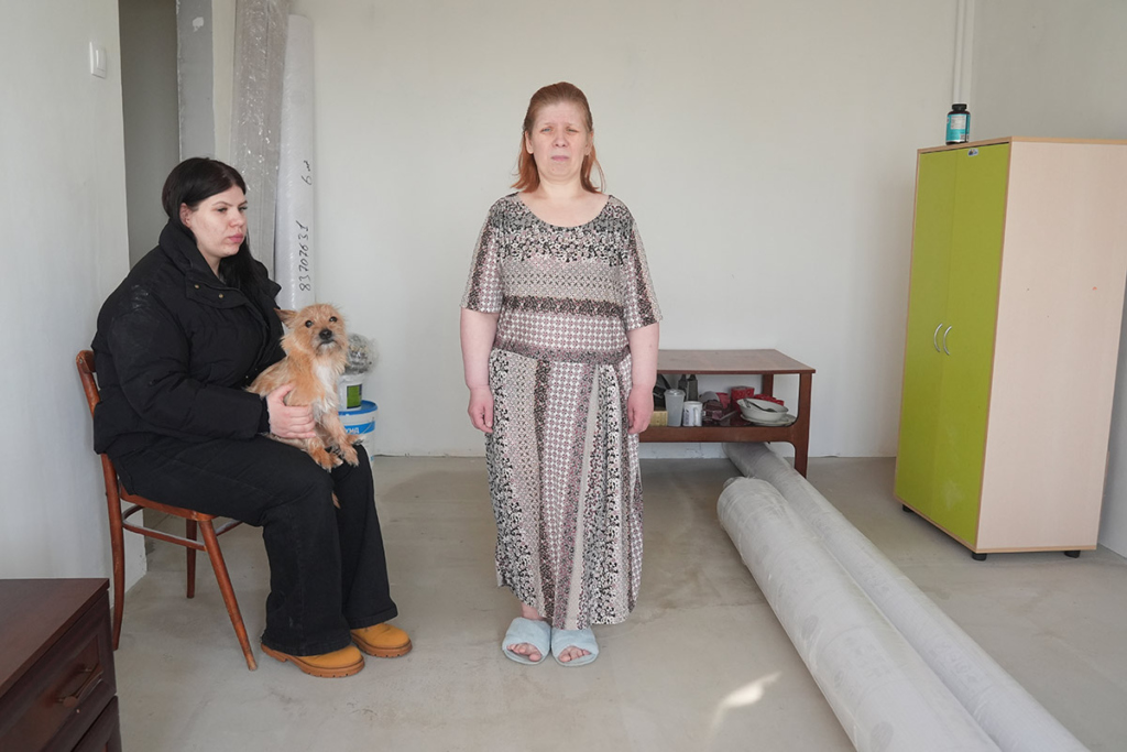 Женщина и ее дочь с собачкой в квартире, в которой идет ремонт 