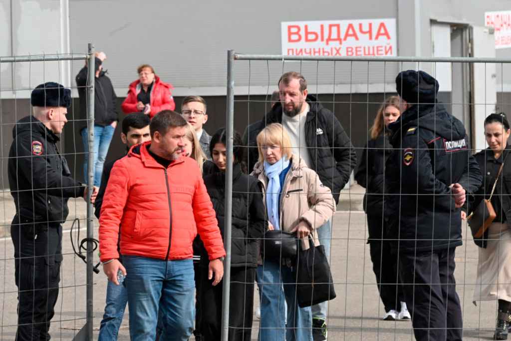 Люди на месте выдачи личных вещей в здании концертного зала "Крокус Сити Холл", где произошла стрельба и начался пожар