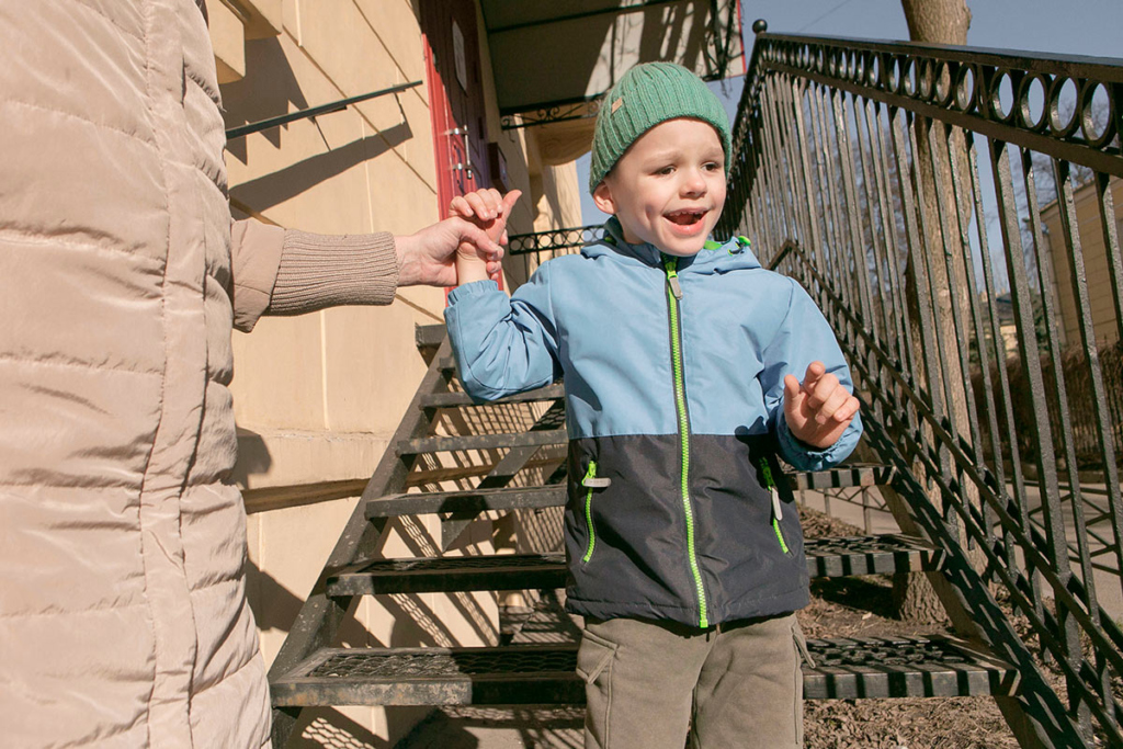 Мальчик спускается по лестнице за руку 