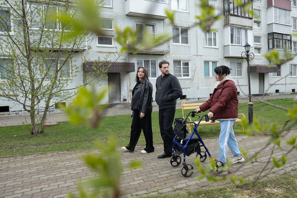 Семья гуляет по улице: муж с женой и мама жены 